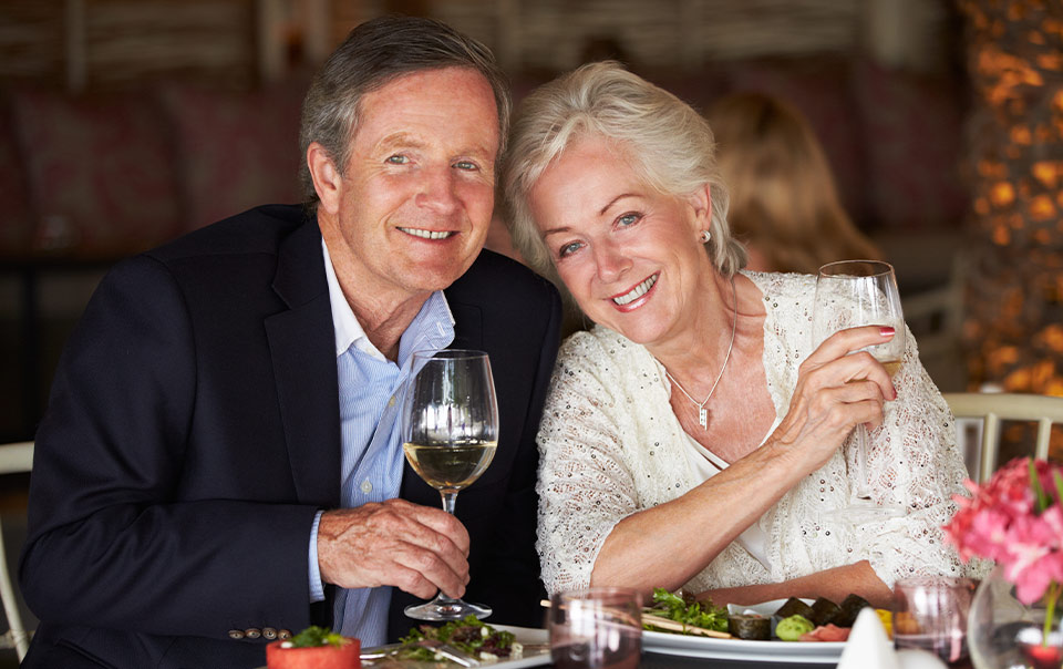 portrait of couple at a restaurant with their complimentary meals at one of our educational seminars houston tx